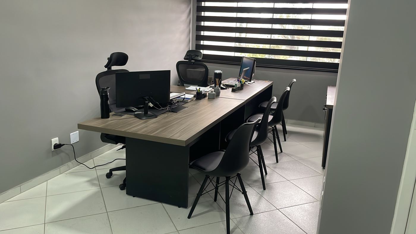 Sala de trabalho com mesa ampla e cadeiras para reuniões